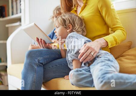 Mutter und zwei Söhne, Blick auf digital-Tablette, Mittelteil Stockfoto