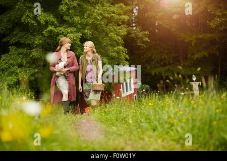 Frauen im Feld tragen Henne und Ei-Korb Stockfoto