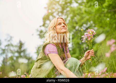 Porträt von Reife Frau Kommissionierung Wildblumen Wiese Stockfoto