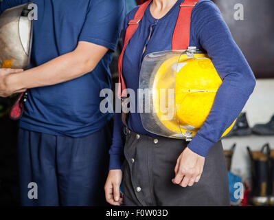 Feuerwehr Helme an Feuerwache halten Stockfoto