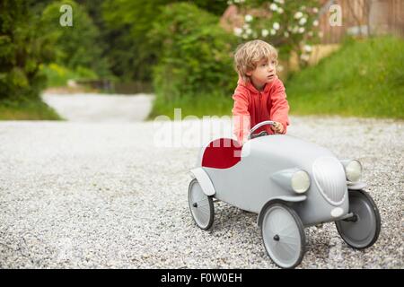 Jungen spielen mit Vintage Spielzeugauto im Freien, wegschauen Stockfoto