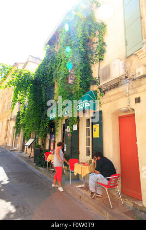 Kunde sitzt in einem Café-Tisch thront auf einer schmalen Bürgersteig in Arles, Frankreich Stockfoto