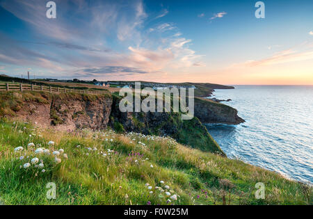 Sonnenuntergang von Klippen oberhalb Port Gaverne und Blick auf Port Isaac Stockfoto