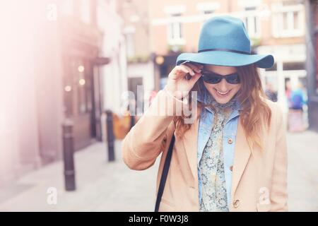 Modisch junge weibliche Shopper mit Sonnenbrille, London, UK Stockfoto