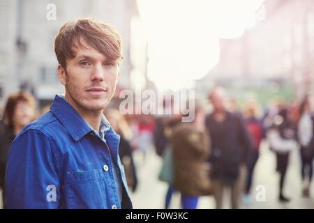 Porträt von Mitte erwachsenen Mannes auf belebten Straße, London, UK Stockfoto