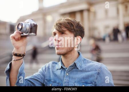 Mitte erwachsener Mann Fotografieren am Trafalgar Square Brunnen, London, UK Stockfoto