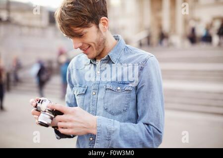 Mitte erwachsenen Mannes Überprüfung Kamera Fotos, Brunnen der Trafalgar Square, London, UK Stockfoto