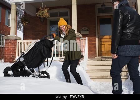 Paar mit Kinderwagen im winter Stockfoto