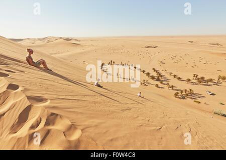 Mutter und Söhne sitzen auf Sand Dune, Dune 7, Namib-Naukluft-Nationalpark, Afrika Stockfoto