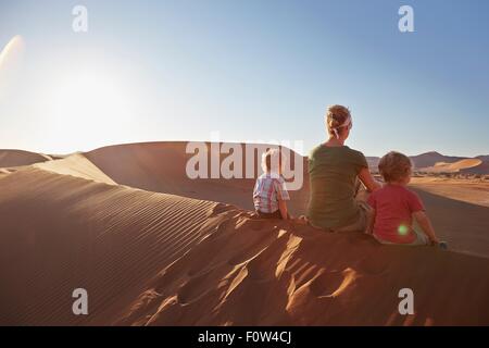 Mutter und Söhne sitzen auf Sanddüne, Namib Naukluft National Park, Namib Wüste, Sossusvlei, Dead Vlei, Afrika Stockfoto