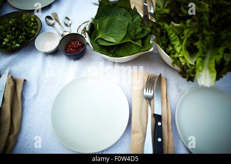 Gedeckten Tisch und frisches Gemüse auf Tisch Stockfoto