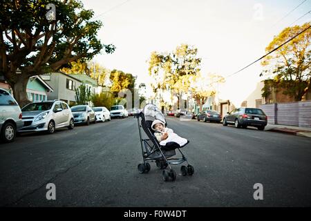 Baby Boy in Kutsche auf der Mitte der Straße Stockfoto