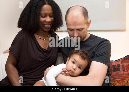 Porträt von Mitte Erwachsenen Eltern und Kleinkind Tochter auf sofa Stockfoto