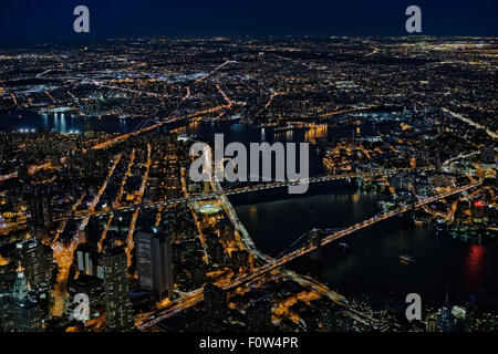 Brooklyn, Manhattan und Williamsburg Brücken Luftaufnahme - ein Blick von oben auf die beleuchtete Lower Manhattan in New York City, die im Stadtbezirk Brooklyn und der Brooklyn, Manhattan und Williamsburg Brücken während der Blauen Stunde der Dämmerung. Stockfoto