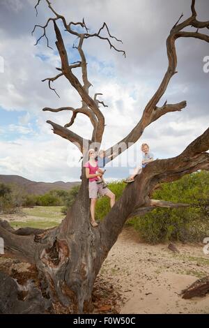 Porträt der Mutter und Söhne, stehend auf toter Baum, Purros, Kaokoland, Namibia Stockfoto