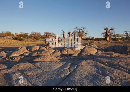 Familie sitzen auf Felsen, Blick auf Ansicht, Gweta, Makgadikgadi, Botswana Stockfoto
