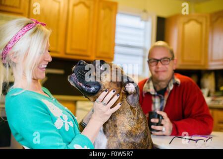 Junge Frau lächelnd an Boxer Hund, von Angesicht zu Angesicht Stockfoto