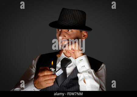 junge Gangster mit Hut Rauchen Zigarre, Studio gedreht Stockfoto
