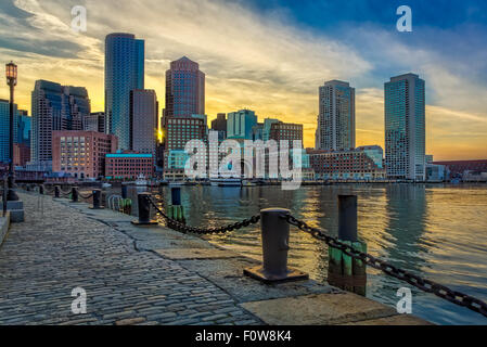 Ventilator Pier Boston Harbor - ein Blick bei Sonnenuntergang zum Boston Hafen mit Skyline der Boston's Financial District und bunten Himmel. Gesehen wird Rowes Wharf, der Odyssee Kreuzfahrt Yachtcharter, zusammen mit anderen Hochhäusern entlang der Uferpromenade. Stockfoto