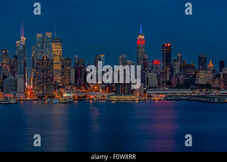 Die Skyline von New York City während der blauen Stunde nach Sonnenuntergang. Das Empire State Building Sport die roten, weißen und blauen Farben. Stockfoto