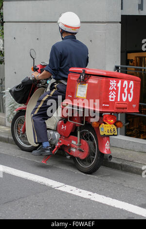 Postamt Zusteller auf roter Roller Stockfoto