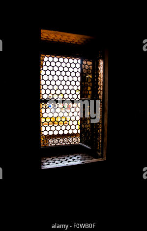 Sonnenlicht durch ein Gitter Fenster in einem dunklen Raum. Stockfoto