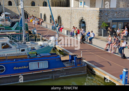 Leute sitzen und Boote in Bristol Floating Harbour am Ende des Millenniums-Promenade Stockfoto