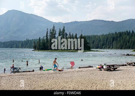 Familien genießen einen schönen Sommertag im Wasser spielen oder Faulenzen am menschenleeren Strand im Strandbad Lake Wenatchee, Washington Stockfoto