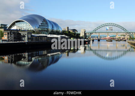 Die Sage Gateshead Performing Arts Centre und Tyne Bridge in Newcastle-upon-Tyne, England. Sie spiegeln in den Fluss Tyne. Stockfoto