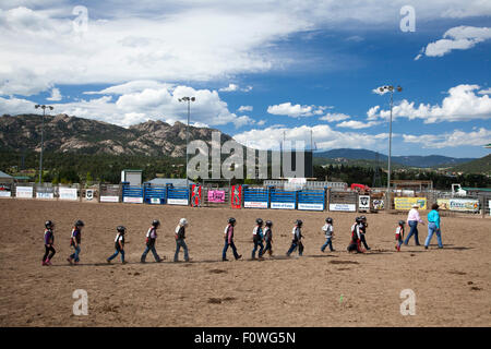 Estes Park, Colorado - Kinder im Alter von 5-8 Kreuz eine Arena bei ihrer Vorbereitung auf die Schafe in einem Rodeo Mutton Bustin ' Wettbewerb zu fahren. Stockfoto