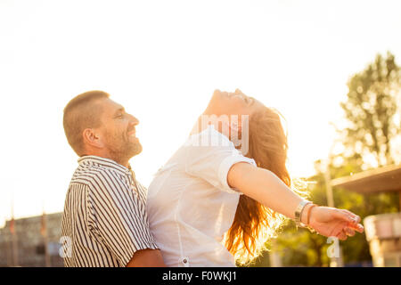 Glückliches Paar Enjoing Zusammenlebens - fotografiert bei Sonnenuntergang gegen Sonne Stockfoto