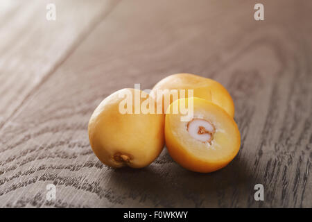 frische rohe Datteln am Tisch Eiche Altholz Stockfoto