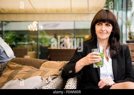 Senior Business-Frau outdoor im street Bar Mojito trinken Stockfoto