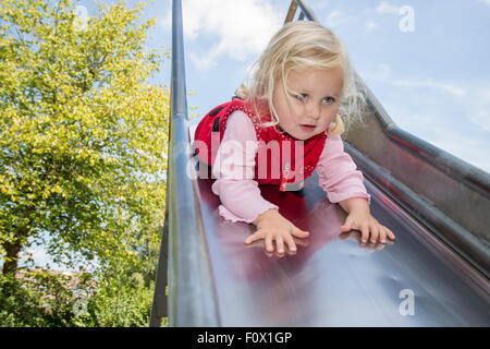 Kleines Mädchen Kopf zuerst rutschen. Stockfoto