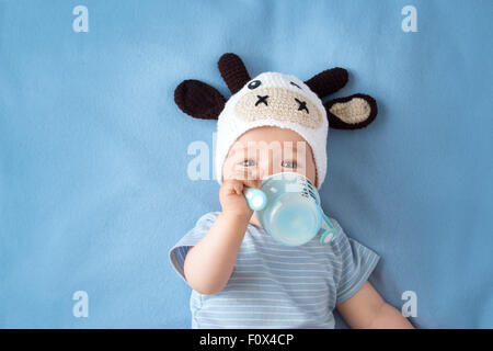 Baby mit Milch Kuh Hut Stockfoto