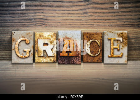 Das Wort "Gnade" in rostigen Metall Buchdruck Typ sitzen auf einem hölzernen Felsvorsprung Hintergrund geschrieben. Stockfoto
