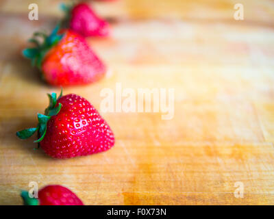 Reihe von Erdbeeren auf einem Holzbrett mit dem leeren Raum Stockfoto