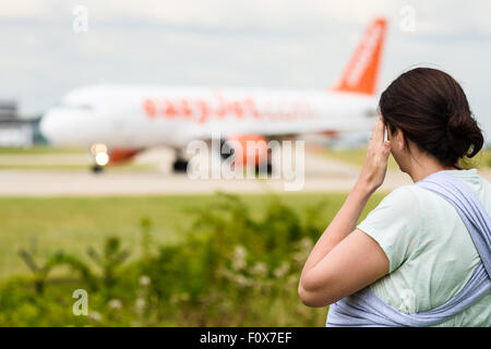 Junge Frau, die ihre Stirn abwischen, da sie sieht auf einem Easyjet Flugzeug will Manchester Airport abgehen Stockfoto