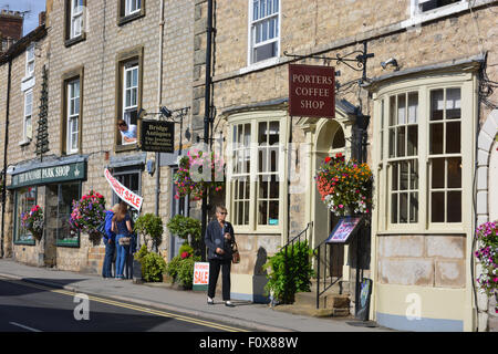 Straßenszene, einschließlich Träger Coffee Shop und Brücke Antiquitäten mit einem Ruhestand Verkaufsschild, Helmsley, North Yorkshire, England Stockfoto