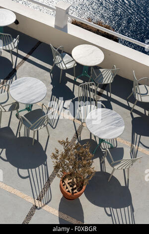 Tische und Stühle auf der Terrasse des Restaurants der Caldera in Fira, Santorini, Griechenland Stockfoto