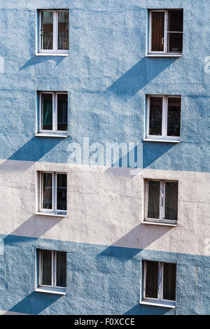 mehrstöckige Wohngebäude Wand mit Fenstern beleuchtet durch die Gegenüberstellung von Sonnenlicht Morgen Stockfoto