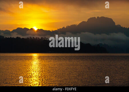 Sonnenuntergang am KLONG SAENG CHEOW EN See im KHAO SOK Nationalpark - THAILAND Stockfoto