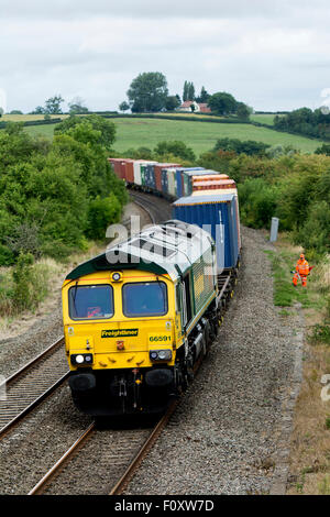 Eine Class 66 Diesel Lokomotive zieht ein freightliner Zug am Knightcote, Warwickshire, Großbritannien Stockfoto
