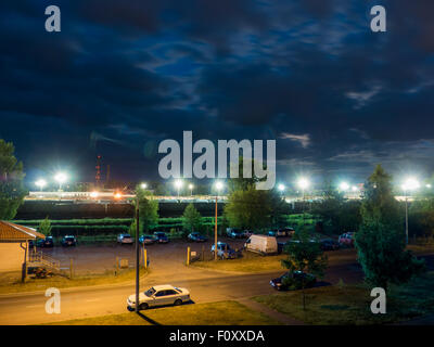 Parkplatz in der Nacht mit Straßenlaternen und erstaunlich dunkle Wolken Stockfoto