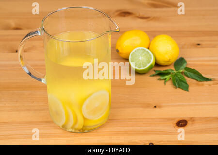 Limonade mit zwei Zitronen, Limette und Minze, Holz Hintergrund Stockfoto