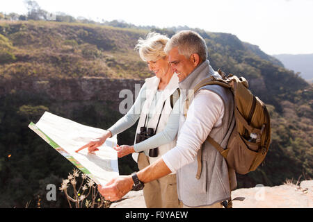 aktive mittlere gealterte Wanderer Blick auf eine Karte oben auf dem Berg Stockfoto