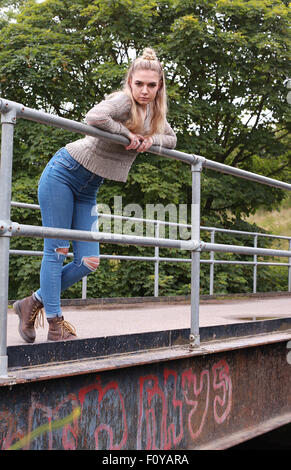 Schwierige Teenager-Mädchen beugte sich über eine industrielle Brücke mit einer Scheidewand in ihrer Nase Stockfoto