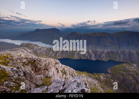 Das dunkle Wasser der Gorm Loch Mor unter A' Mhaighdean. Slioch ist auf der linken Seite hinter Lochan Fada ersichtlich. Stockfoto