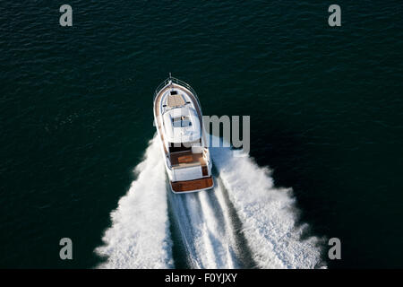 Elegante weiße Yacht Segeln durch dunkle tiefen Gewässern an einem sonnigen Abend Stockfoto