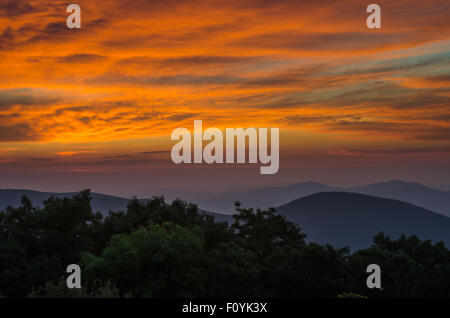 Der Himmel wird brilliant Orange und lila, wie die Sonne über den Blue Ridge Mountains in Virginia Stockfoto